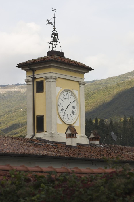 Particolare dell'orologio della fabbrica sullo sfondo le colline del val di Bisenzio.