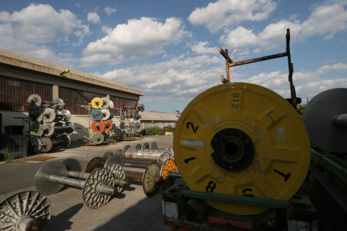 Ripresa di uno stabilimento tessile in primo piano un subbio.