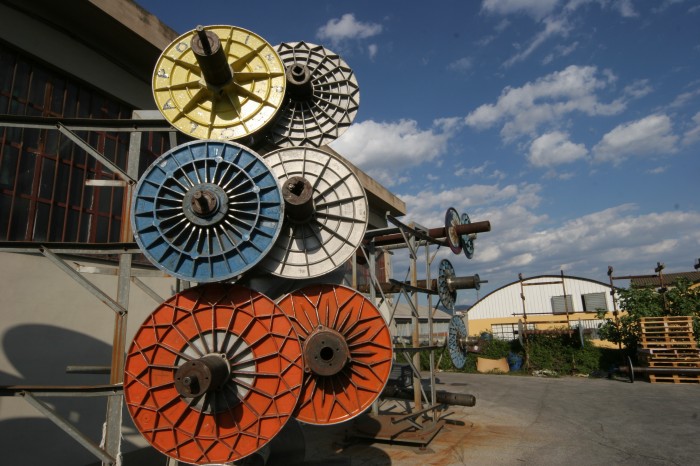 Primo piano di un castello metalico contenente alcuni subbi per tessitura.