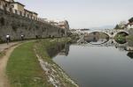 Ripresa del fiume Bisenzio dalla pista ciclabile che costeggia le mura nello sfondo si nota il ponte del Mercatale.