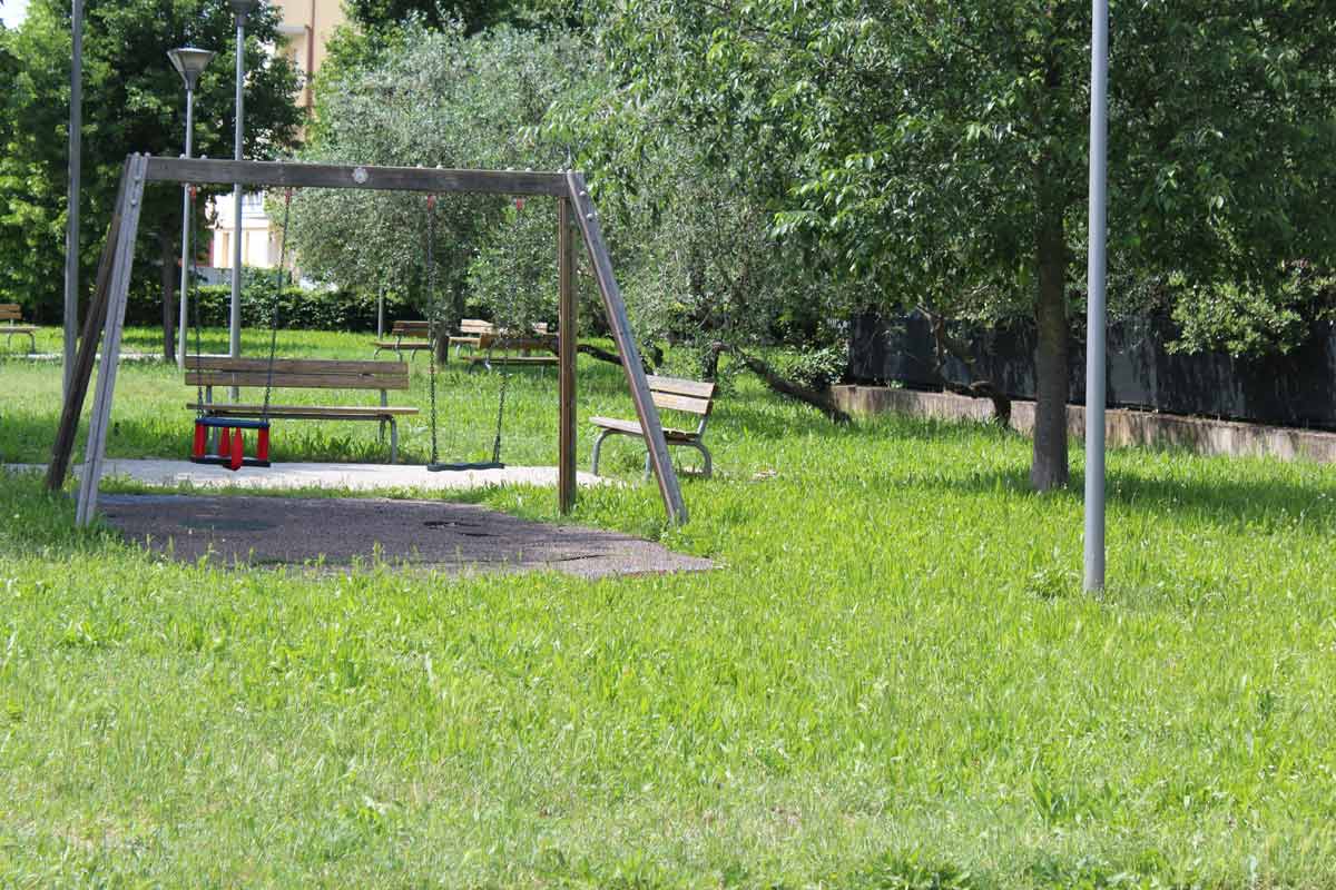 Giardino Menabuoni con panchine e gioco dell'altalena provvisto di pavimentazione apposita per il trauma da caduta