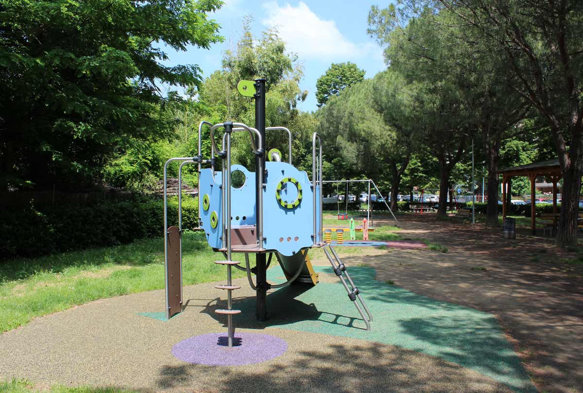 Area ludico motoria con scivolo, altalene e giochi a molla accanto all'area coperta del giardino Picasso