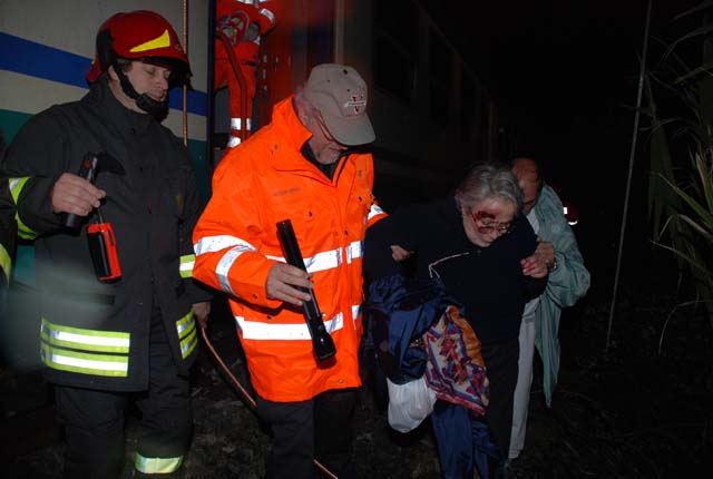 Un tecnico dei Vigili del Fuoco ed un volontario mentre accompagnano, lungo la massicciata, una persona simulata quale "ferito ma deambulante"