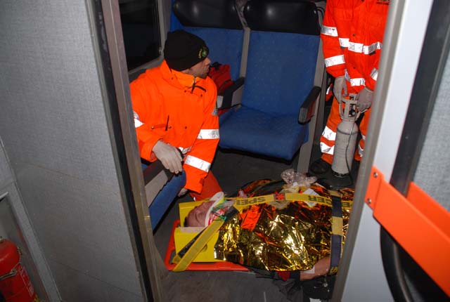 Due soccorritori all'interno del treno mentre si accingono a far scendere un simulatore ferito posizionato su una barella