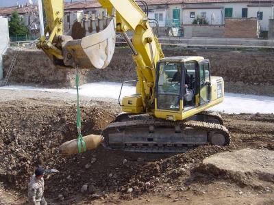 L'ordigno dispolettato, appeso alla benna di una escavatore, viene rimosso dal luogo di ritrovamento per il suo trasporto
