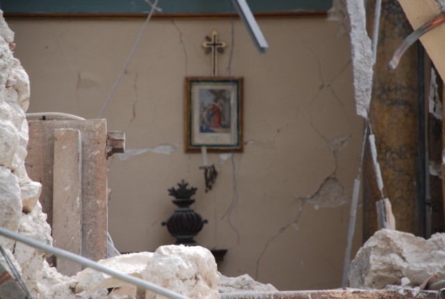 Una immagine di una camera da letto visibile a causa del crollo della parete frontale dell'edificio