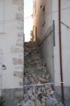 Un vicolo in discesa dell'abitato di Castelnuovo completamente invaso dalle macerie di costruzioni poste a monte e crollate a seguito del sisma