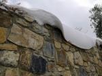 A causa del vento la neve posata su un muretto ha assunto una forma particolare