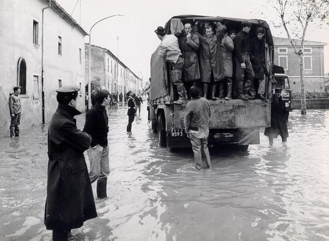 Persone evacuate che si trovano sul cassone di un camion