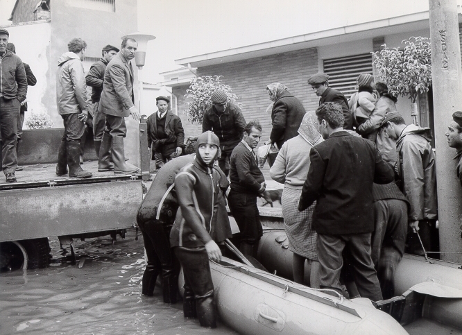 Gente che scende da un gommone di salvataggio sulla piazzola rialzata del circolo di Tavola