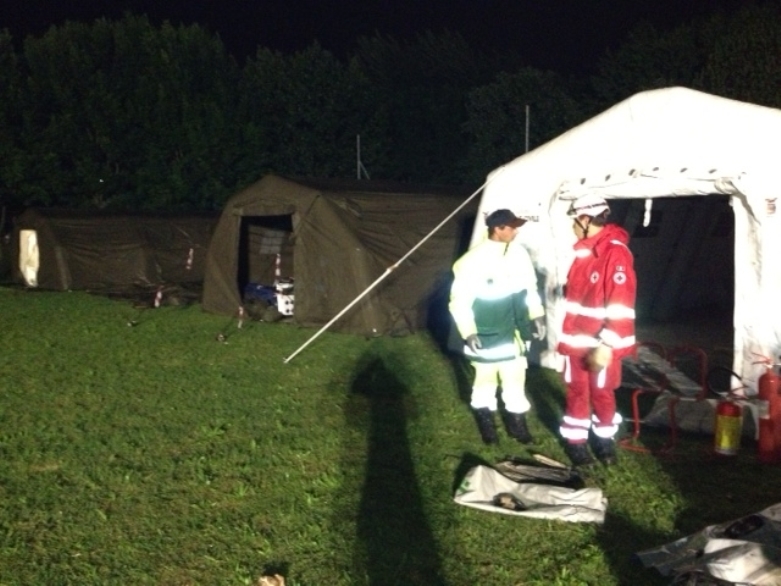 Immagine notturna dei volontari della Regione Toscana durante le fasi di allestimento del Campo di San Possidonio